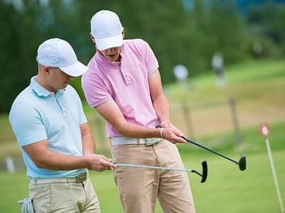 Golf instructor teaching beginner swing